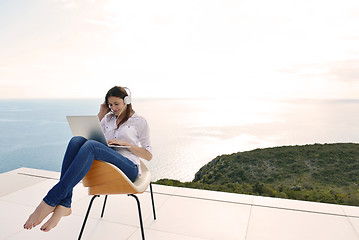 Image showing relaxed young woman at home working on laptop