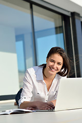 Image showing relaxed young woman at home working on laptop computer