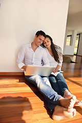 Image showing relaxed young couple working on laptop computer at home