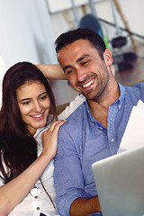 Image showing relaxed young couple working on laptop computer at home