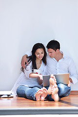 Image showing relaxed young couple working on laptop computer at home