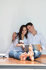 Image showing relaxed young couple working on laptop computer at home