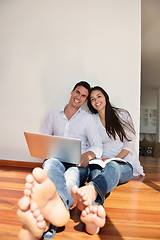 Image showing relaxed young couple working on laptop computer at home