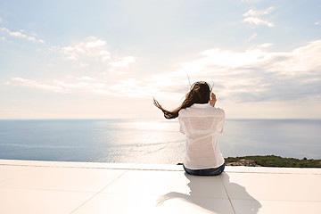 Image showing girl listening to the music on white headphones