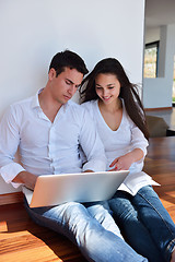 Image showing relaxed young couple working on laptop computer at home