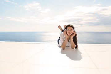 Image showing girl listening to the music on white headphones