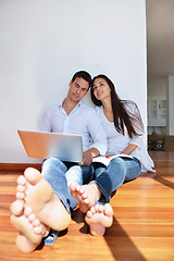 Image showing relaxed young couple working on laptop computer at home