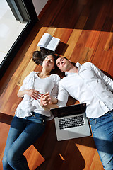 Image showing relaxed young couple working on laptop computer at home