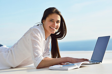 Image showing relaxed young woman at home working on laptop computer