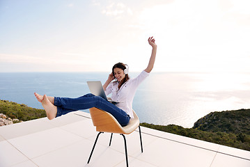 Image showing relaxed young woman at home working on laptop