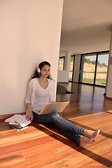 Image showing relaxed young woman at home working on laptop