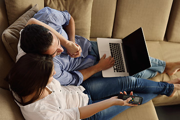 Image showing relaxed young couple working on laptop computer at home