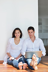 Image showing relaxed young couple working on laptop computer at home