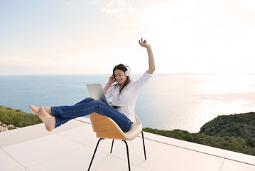 Image showing relaxed young woman at home working on laptop