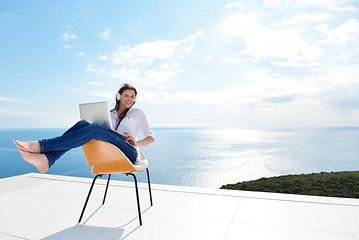 Image showing relaxed young woman at home working on laptop