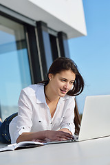 Image showing relaxed young woman at home working on laptop computer