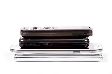 Image showing Stack of older model cell phones and smartphones