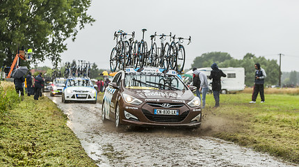 Image showing Row of Technical Cars on a Cobbled Road - Tour de France 2014