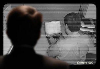 Image showing Man observing an employee work via a closed-circuit video monito