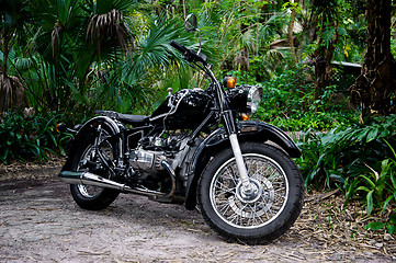 Image showing vintage black motorcycle in tropical setting