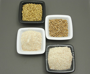 Image showing Bowls of chinaware with cereal and wholemeal on gray matting
