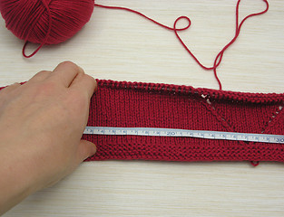 Image showing Red knitting with whole pattern and measuring tape