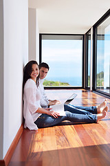 Image showing relaxed young couple working on laptop computer at home