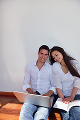 Image showing relaxed young couple working on laptop computer at home