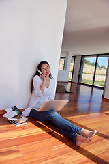 Image showing relaxed young woman at home working on laptop