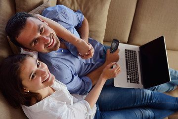 Image showing relaxed young couple working on laptop computer at home