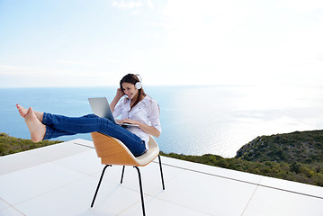 Image showing relaxed young woman at home working on laptop