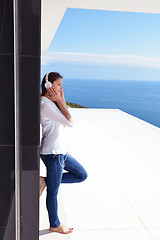 Image showing girl listening to the music on white headphones