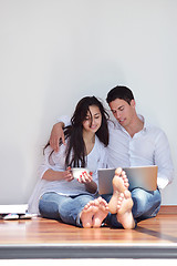 Image showing relaxed young couple working on laptop computer at home