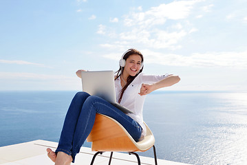 Image showing relaxed young woman at home working on laptop