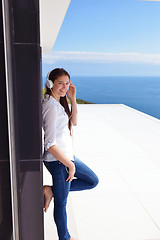 Image showing girl listening to the music on white headphones