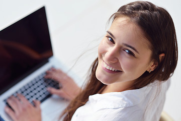 Image showing relaxed young woman at home working on laptop computer