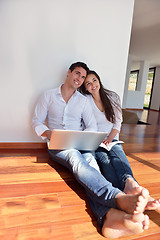 Image showing relaxed young couple working on laptop computer at home