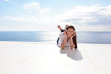 Image showing girl listening to the music on white headphones