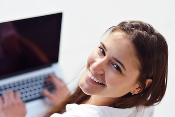 Image showing relaxed young woman at home working on laptop computer