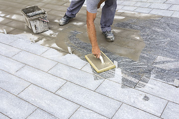 Image showing Grouting tiles on the floor