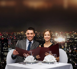 Image showing smiling couple with menus at restaurant