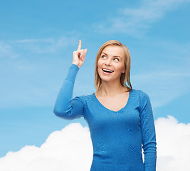 Image showing smiling woman pointing her finger up