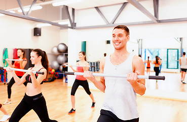 Image showing group of smiling people working out with barbells