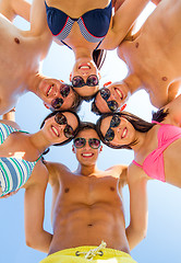 Image showing smiling friends in circle on summer beach