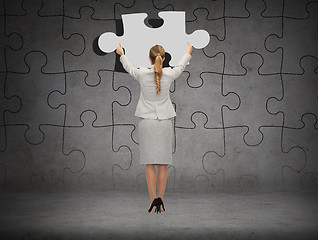 Image showing businessman in suit setting piece of puzzle