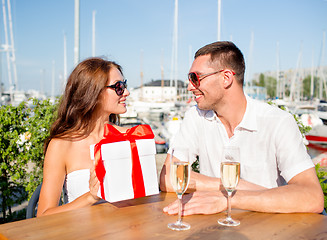 Image showing smiling couple with gift box cafe