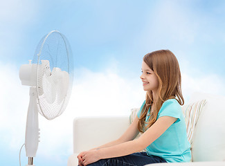 Image showing smiling little girl with big fan at home