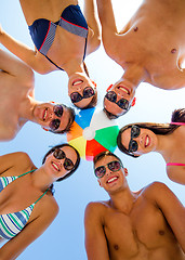 Image showing smiling friends in circle on summer beach