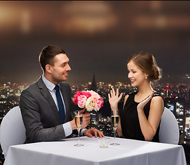 Image showing smiling man giving flower bouquet to woman