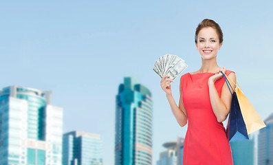 Image showing smiling woman in red dress with shopping bags